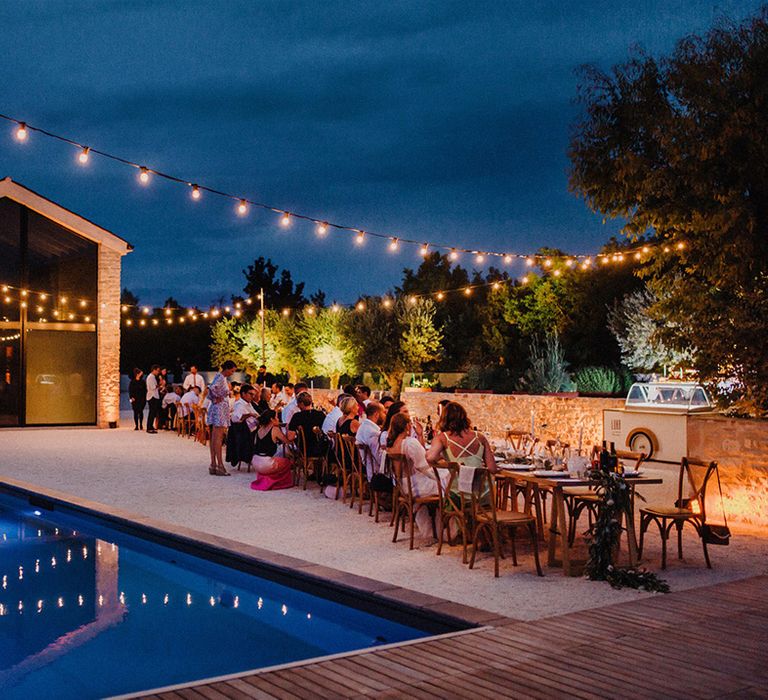 Villa lit up at night with fairy lights next to swimming pool in Croatia 