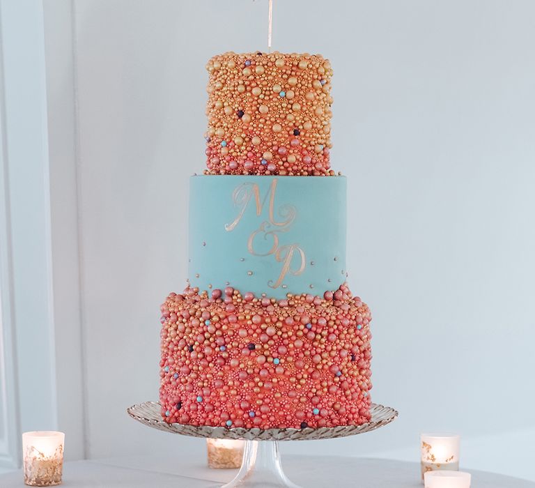 bright pink and blue wedding cake with bauble decor and hoop cake topper 