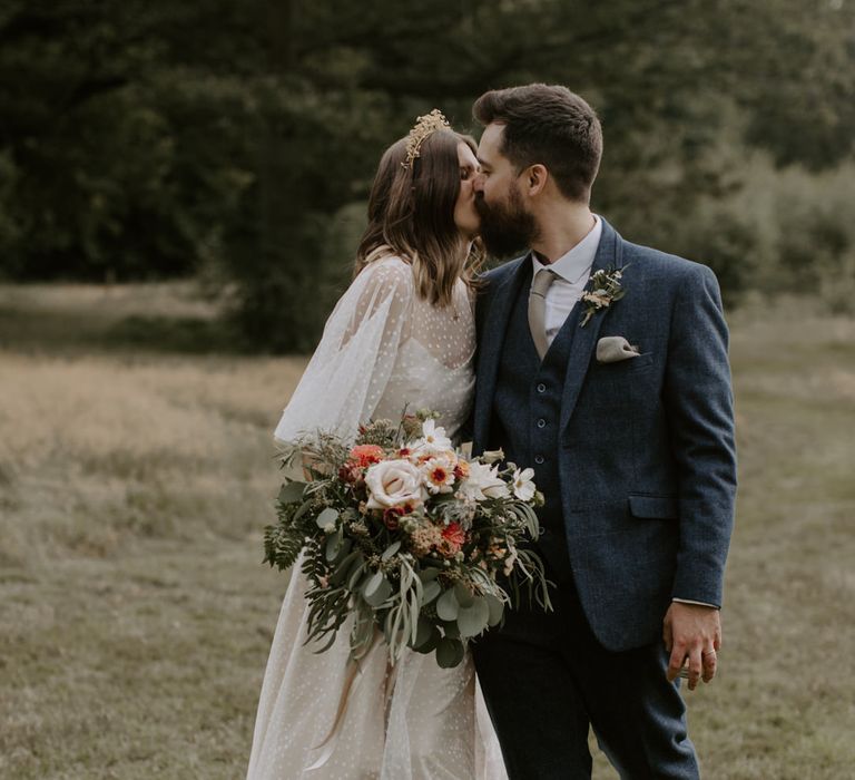 Bride & groom kiss outdoors on their wedding day