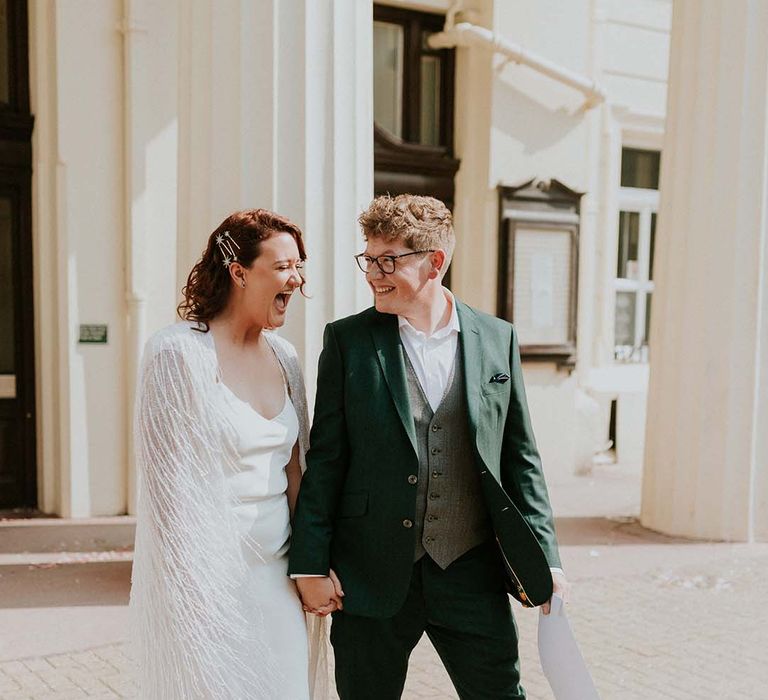 Bride & groom look lovingly at one another whilst smiling after wedding ceremony