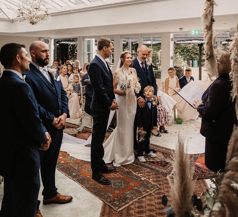 Bride & groom stand at the altar with their son and daughter on their wedding day