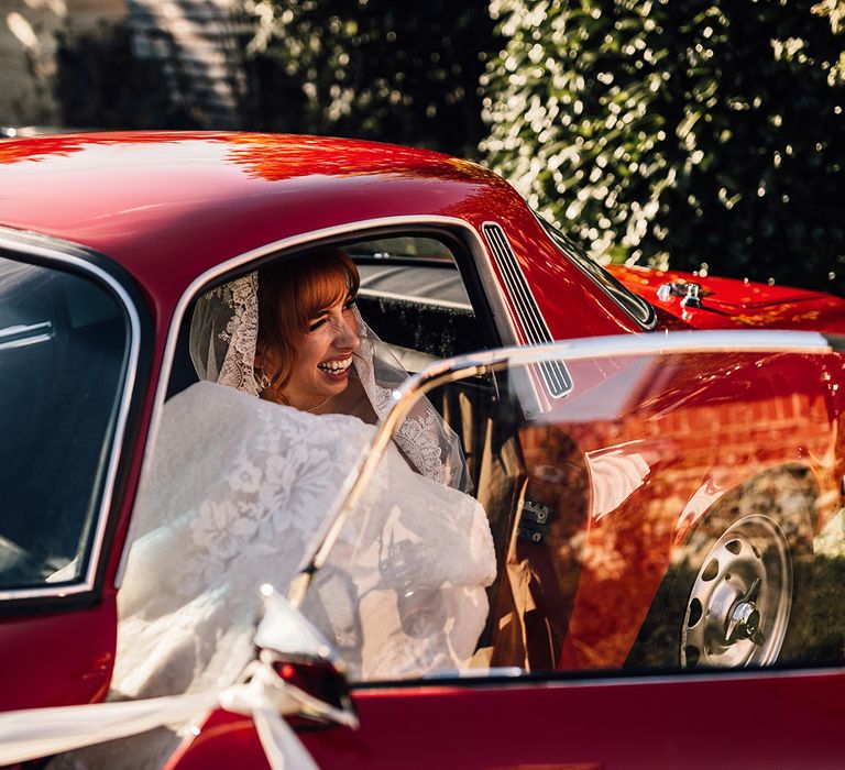 Bride in vintage car at Oxnead Hall wedding venue