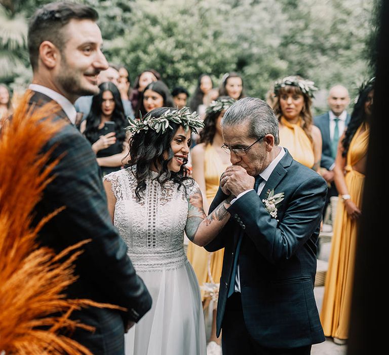 bride & groom stand in front of orange pampas grass on their wedding day