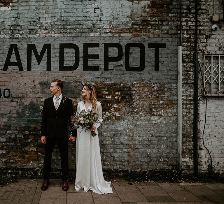 Bride & groom stand for couples portraits on their wedding day