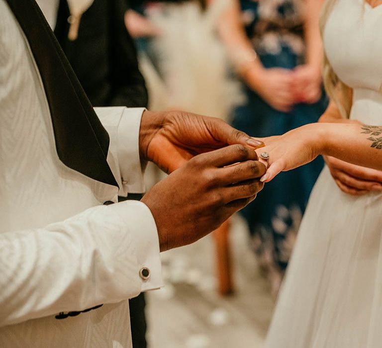 Bride and groom exchange wedding rings during ceremony