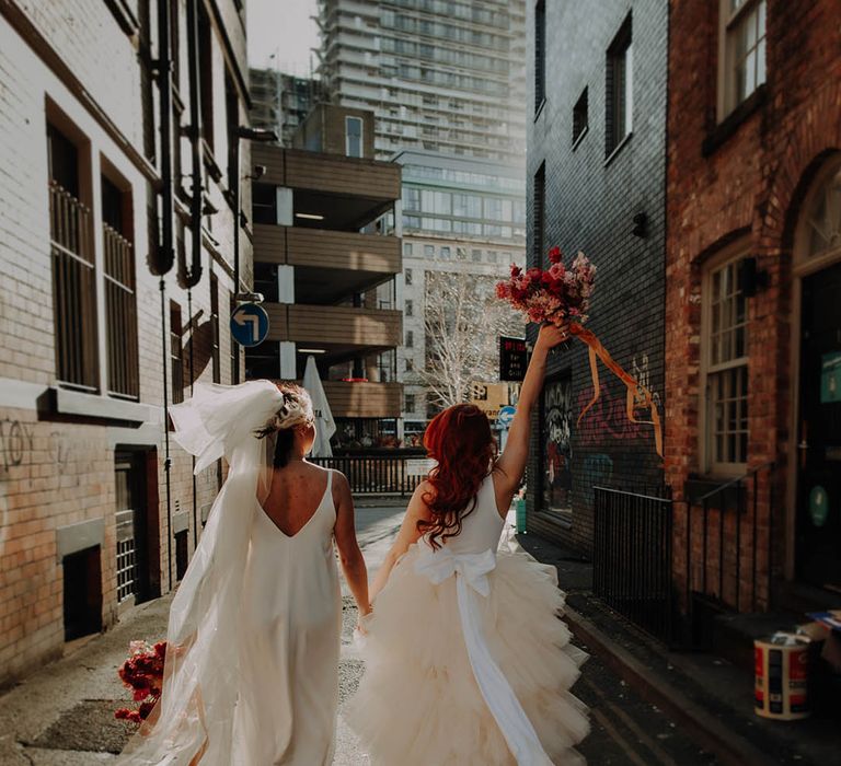 Manchester elopement with two brides in a layererd tulle wedding dress with bow and satin slip wedding dress long bow veil 