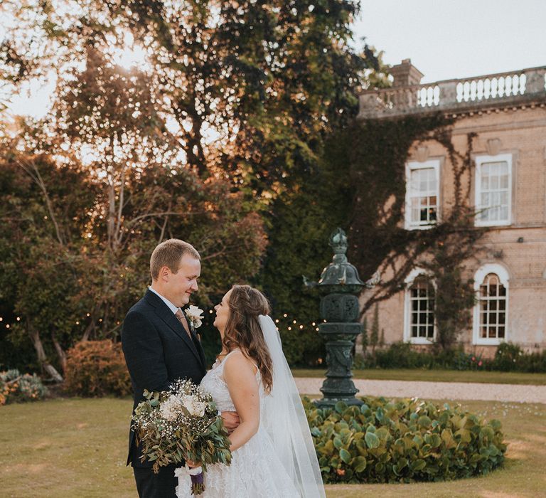 Bride in lace wedding dress with groom in blue checkered suit with yellow tie and handkerchief 