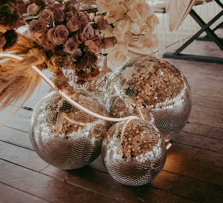 different sixed disco balls on the flowr with cream and cafe au late roses wedding flowers 