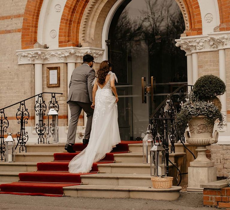 Bride and groom under large exposed orange and neutral brick arch at The Petersham Hotel in Richmond