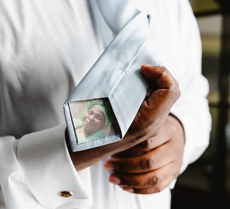 Groom's baby blue tie has a photo of family member printed inside 