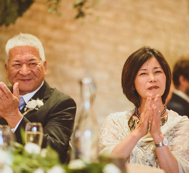 Wedding guests clap as they listen to wedding speeches