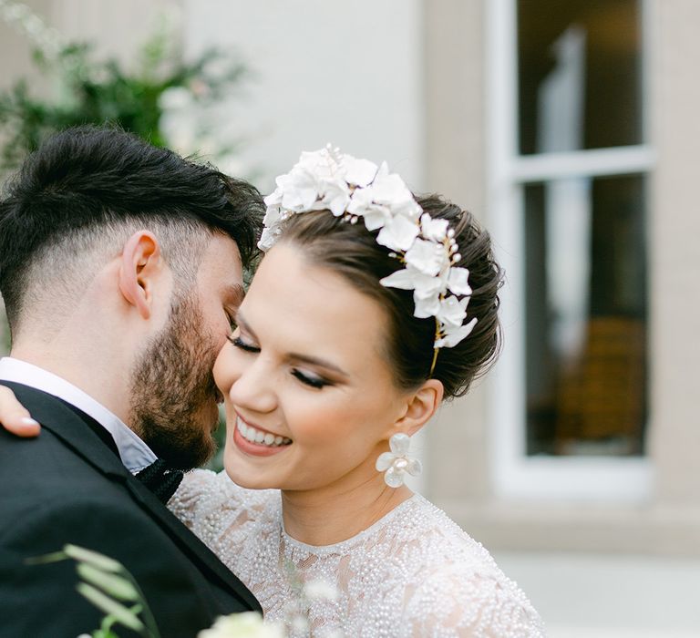 bride in a beaded wedding dres with smokey eyeshadow wearing a flower headdress and matching earrings