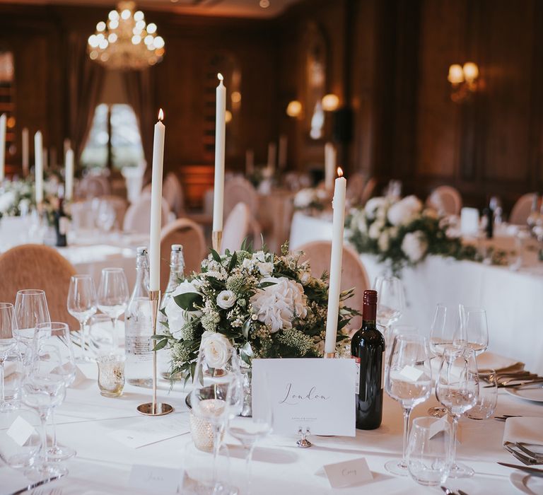 Circular wedding tables with white table cloths for classic wedding with white flower centrepieces 