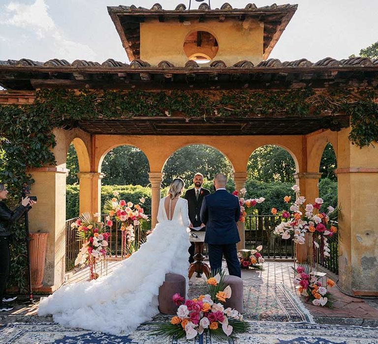 Bride wears Milla Nova wedding gown complete with long tulle skirt and buttoned down back