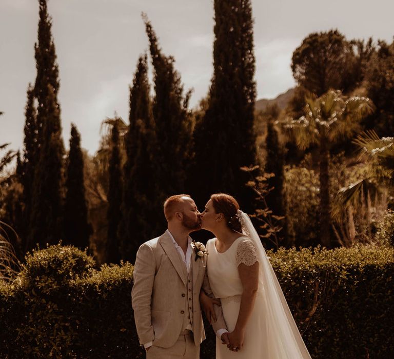 Bride wears floor length veil complete with lace trim on her wedding day