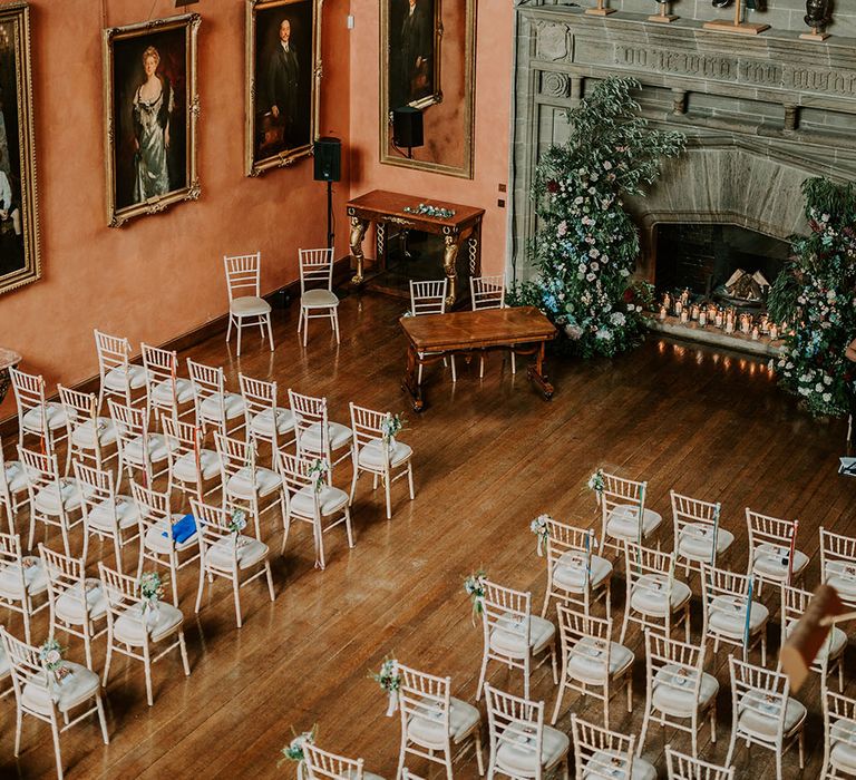 Cowdray House wedding venue complete with large fireplace filled with candles surrounded by pastel florals 