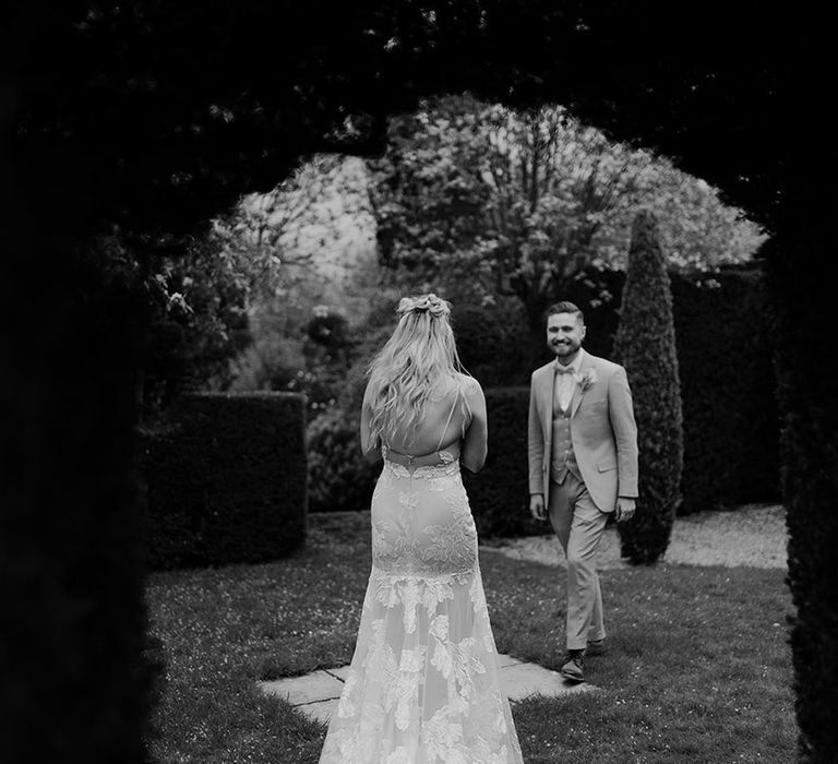 Black & white image of bride & groom in secluded garden before intimate first dance moment