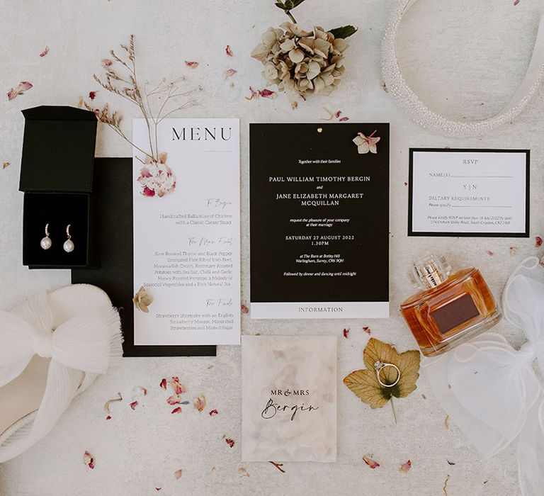 White & black wedding stationery beside Loeffler Randall bridal shoes and perfume