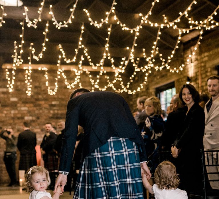 Flower girls wear white dresses complete with tulle styled skirts with silk bow to the back