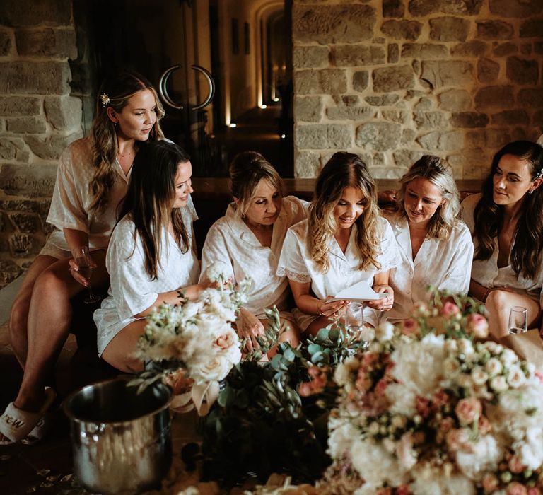 Bridal party and Bride wearing bridal pyjamas whilst reading a letter at destination wedding