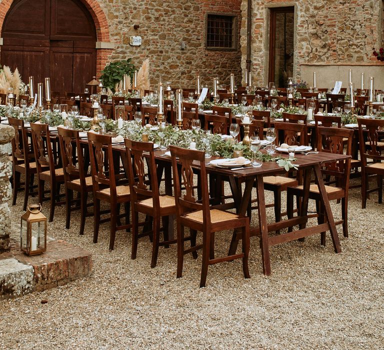 Ecalyptus tablescapes under festoon lighting at oudoor wedding in Italy