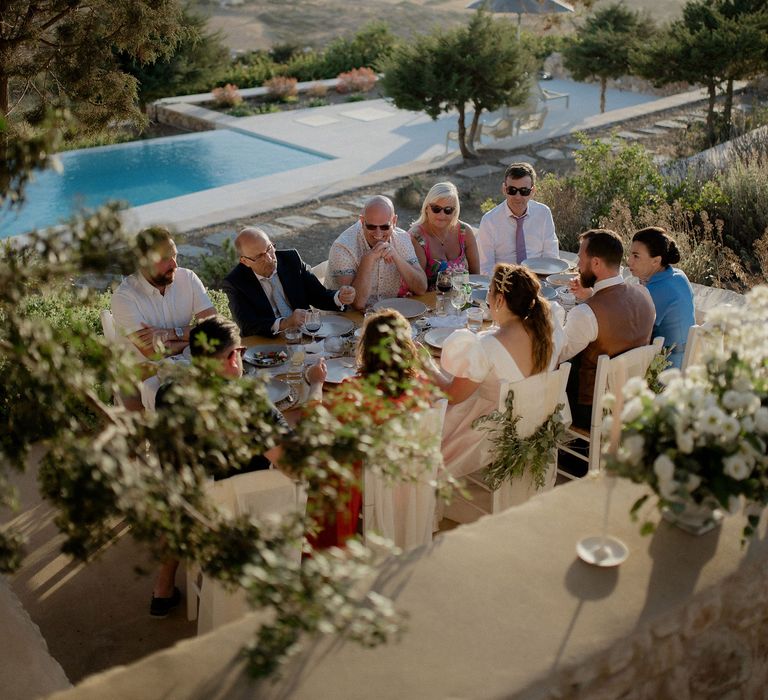 Private villa wedding with white and green floral tablescape, swimming pool and views of the Grecian hills