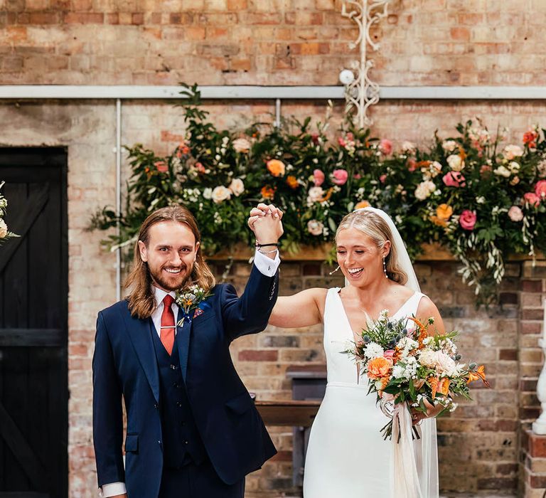 The bride and groom walk back down the aisle as a married couple after their ceremony at Botley Hill Barn wedding venue 