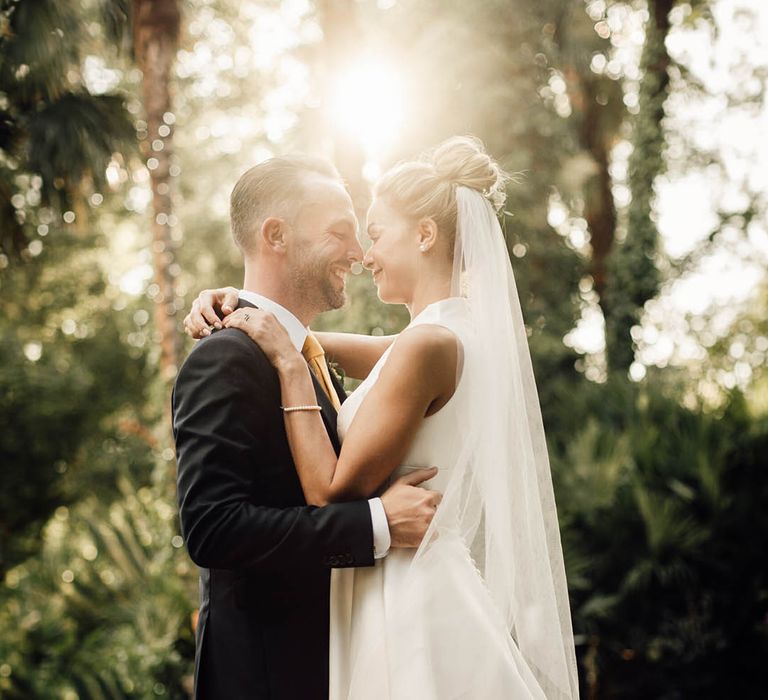 Classic country house wedding with bride in plunging neckline wedding dress with groom during golden hour 