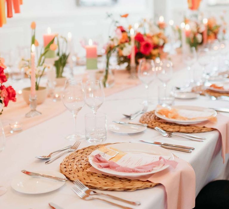 Merriscourt wedding reception room with wedding tablescape with white wedding tablecloth, burlap place mats, tapered candles, pink and orange wedding stationery, and floral wedding table centrepieces with pink and orange garden roses, orange floribunda, yellow ranunculus flowers, foliage and Iceland poppies 