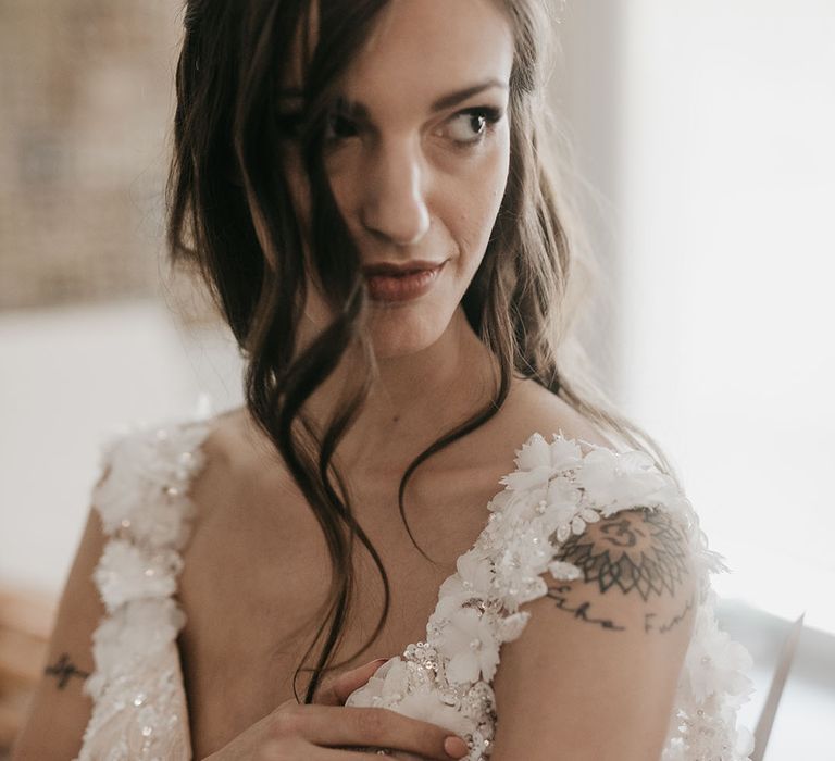 beautiful bride with long brown hair and natural wedding makeup in an appliqué wedding dress