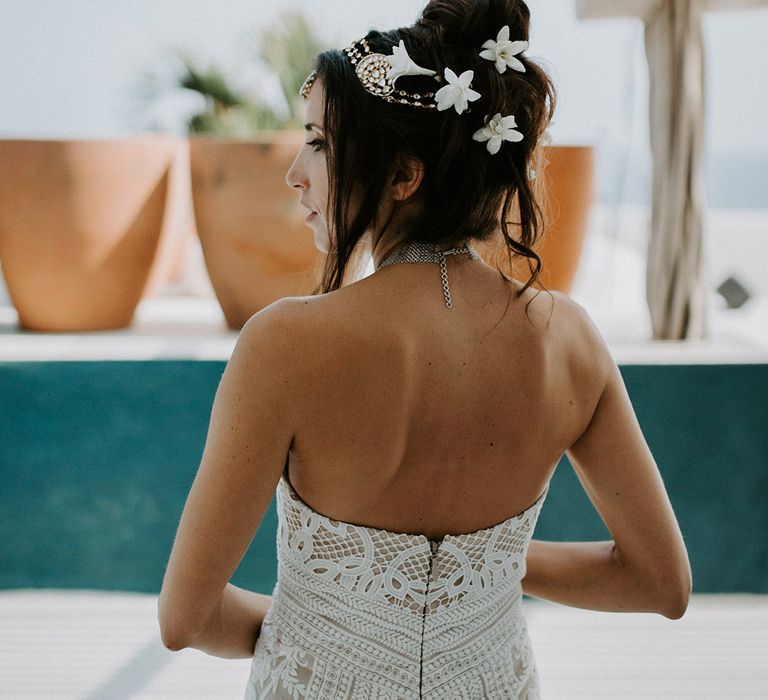 Bride in boho lave strapless wedding dress with a bridal updo featuring white flower hair accessories and a sparkly matha patti