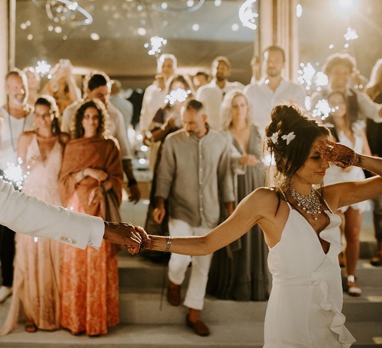 Bride and groom share first dance with guests waving sparklers around them