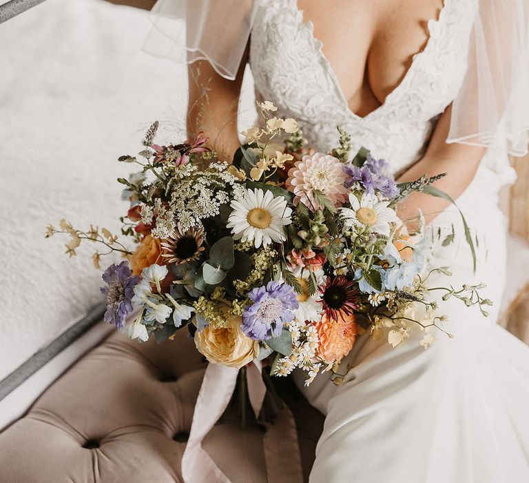 Bride in lace wedding dress with pastel wedding bouquet with white floral headband 