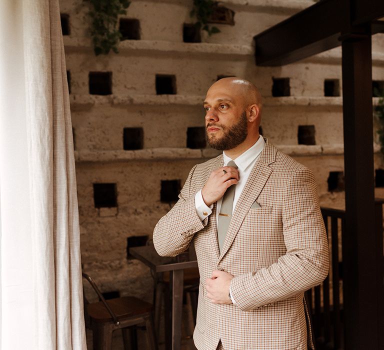 Groom in checkered beige suit for the contemporary style autumn wedding 