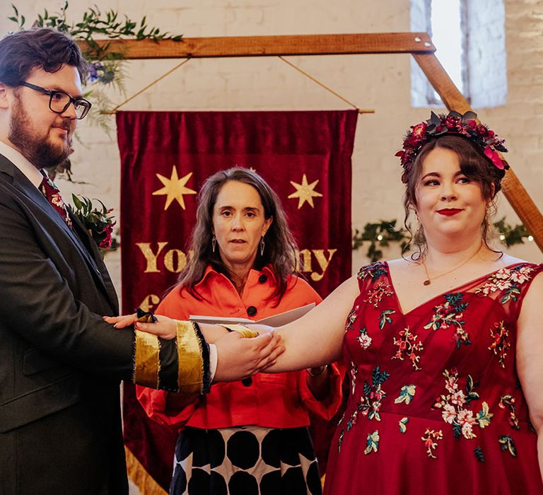 Handfasting wedding ceremony at barn wedding conducted by the bride's cousin 