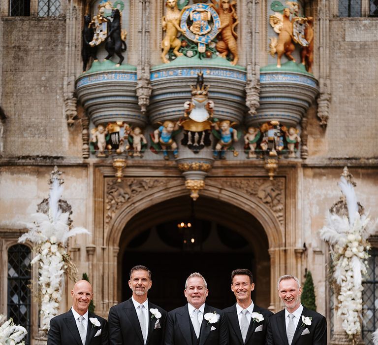 Groomsmen in black suits with light silvery grey ties for classic style wedding 