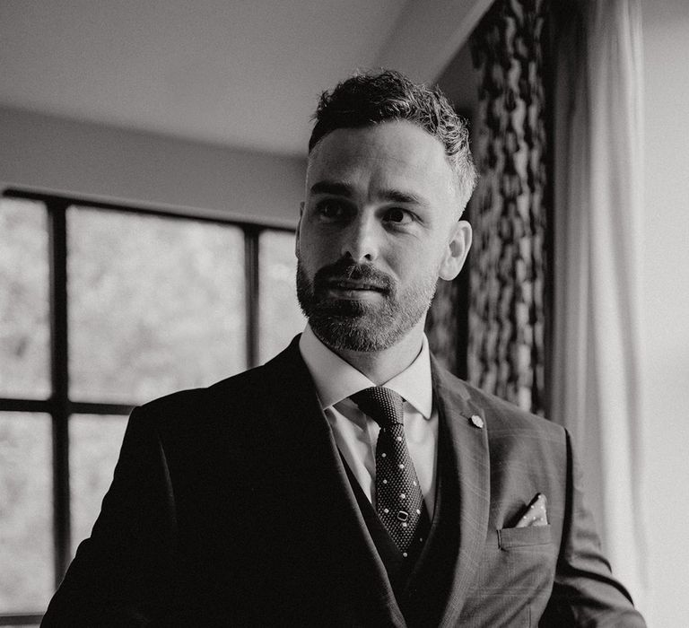 The groom wearing a three piece suit gets ready for the wedding day in London 