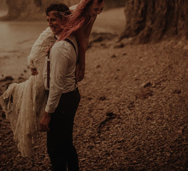 Groom lifting his bride over his shoulder