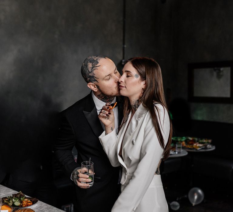 Groom kissing his bride on the cheek 