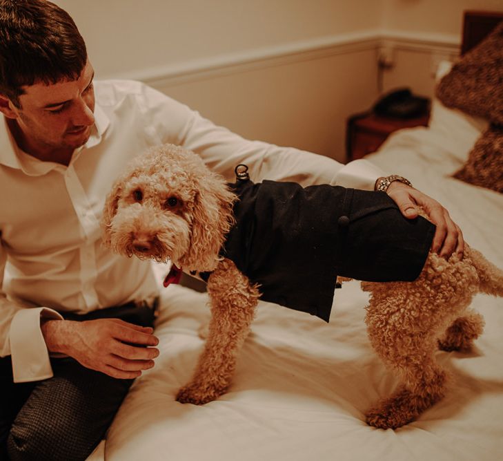 Groom getting read for his winter wedding with his dog