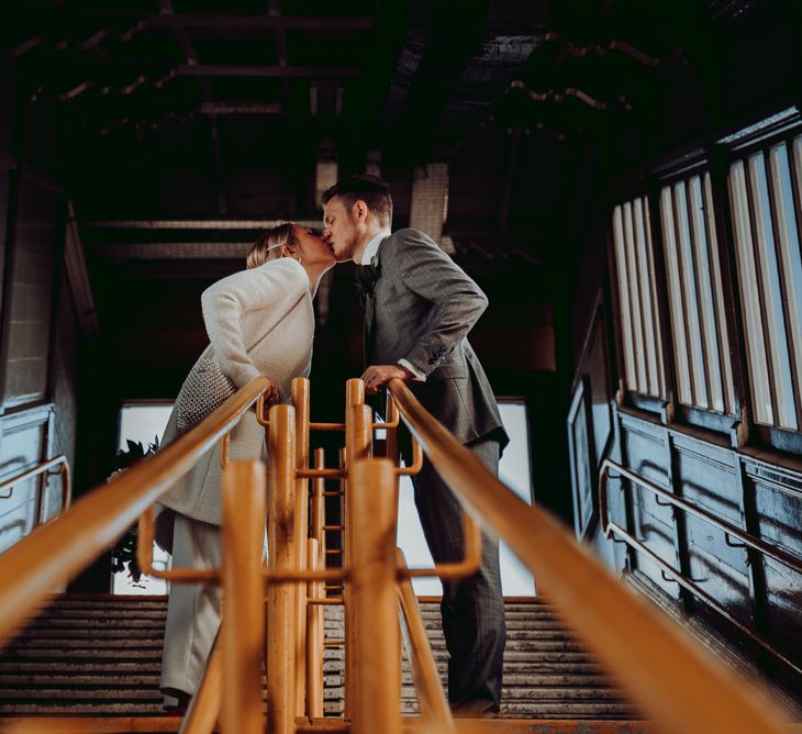 Bride and groom kissing at the tram station 