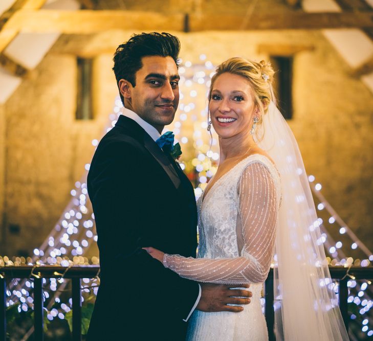 Bride and groom portrait at The Great Tythe Barn with fairy lights backdrop