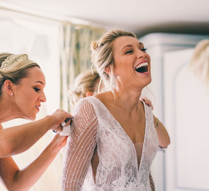 Bride laughing on the wedding morning in embellished wedding dress