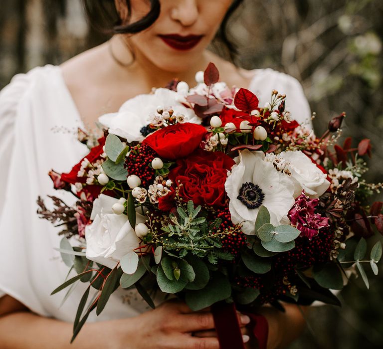 Beautiful Bride with red lip and red and white rose bouquet