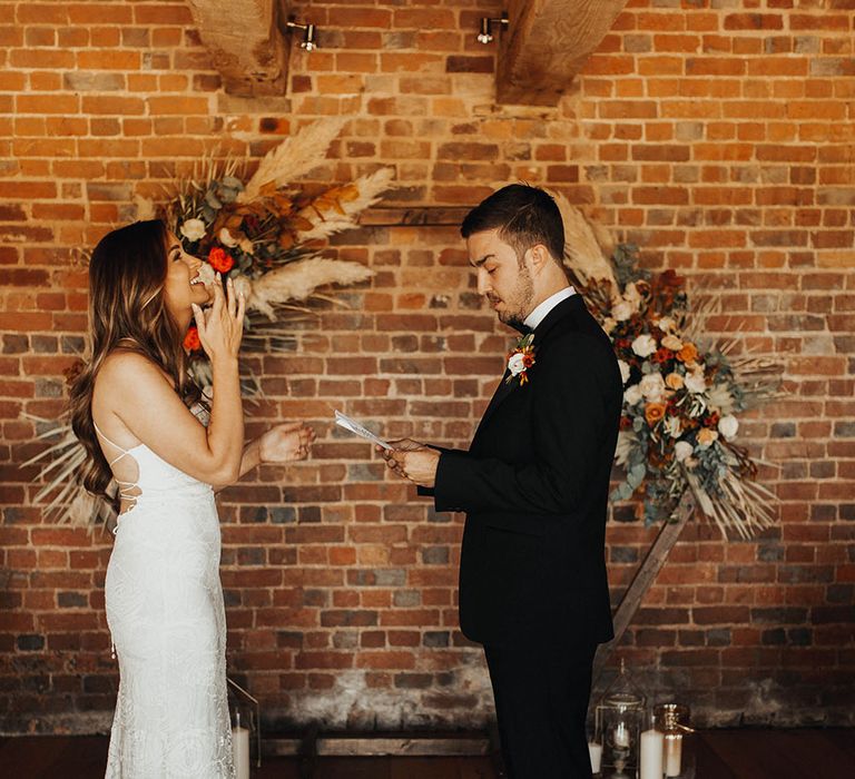 Bride and groom reading vows in wedding ceremony