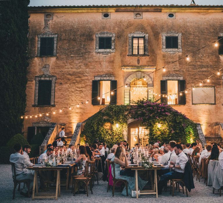 Italian wedding inspiration with bright festoon lights for outdoor evening dinner