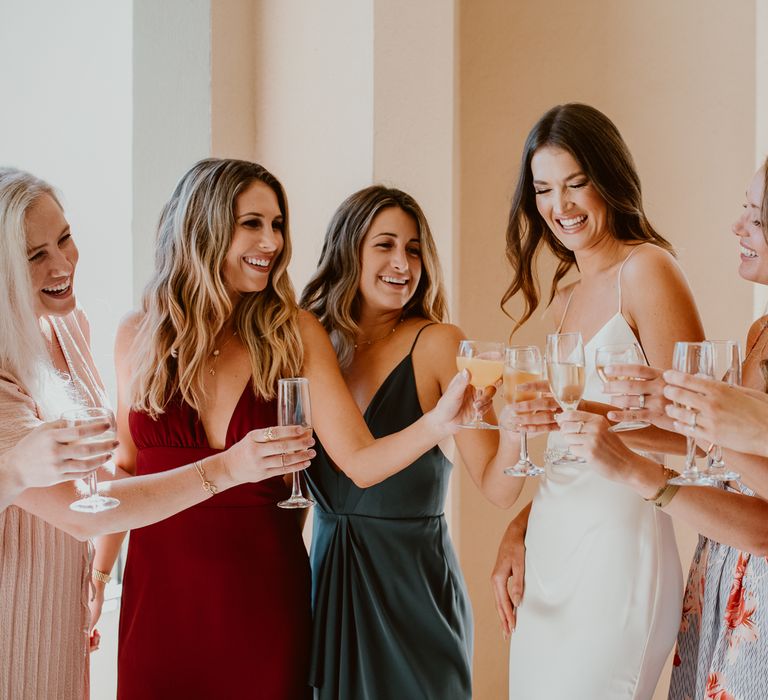 Bride and her bridesmaids toast with champagne