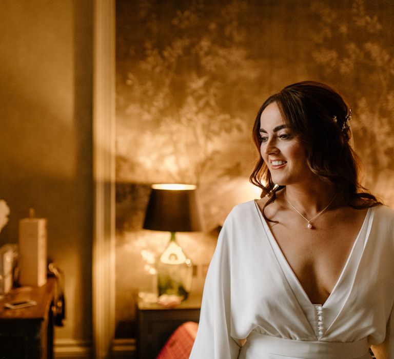 Bride on the morning of her wedding with beautiful pearl necklace and silk bridal gown