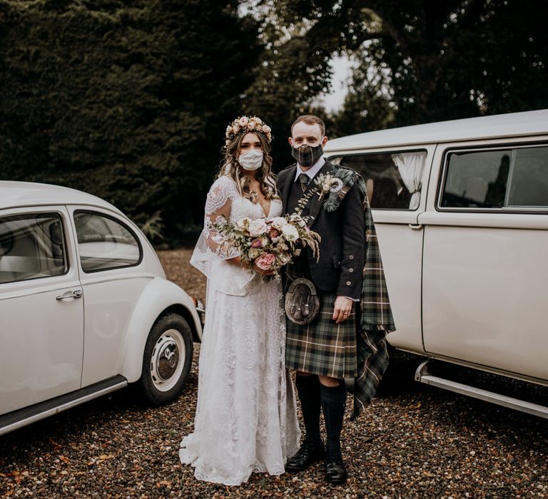 Boho bride in pink rose flower crown and Scottish groom in kilt wearing face masks