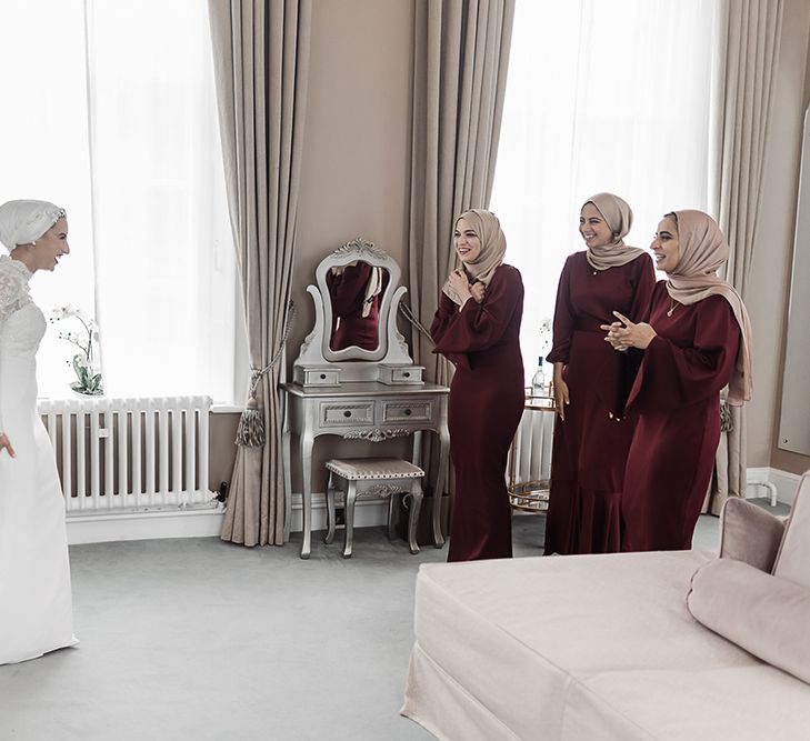 A muslim bride reveals her wedding look to her bridesmaids. 